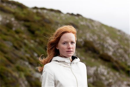 Young redhead woman in hooded shirt looking at camera Stock Photo - Premium Royalty-Free, Code: 6102-08800168