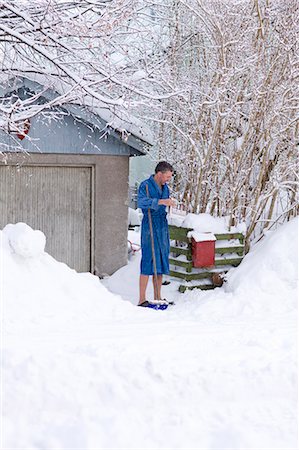 simsearch:6102-03750876,k - Man in bathrobe checking mail in snowy yard Foto de stock - Sin royalties Premium, Código: 6102-08800243