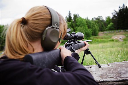 simsearch:6102-08184072,k - Woman target shooting in meadow Foto de stock - Sin royalties Premium, Código: 6102-08800270