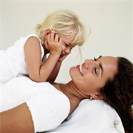 simsearch:6102-06336624,k - Daughter lying on mothers chest Foto de stock - Sin royalties Premium, Código: 6102-08800298