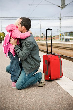 Father and daughter saying goodbye to daughter on railway platform Fotografie stock - Premium Royalty-Free, Codice: 6102-08800207
