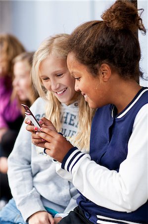 simsearch:6102-07843687,k - Girls sitting together and text messaging Stock Photo - Premium Royalty-Free, Code: 6102-08800238