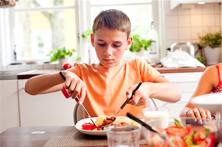 simsearch:6102-03867771,k - A boy eating dinner Stockbilder - Premium RF Lizenzfrei, Bildnummer: 6102-08800393