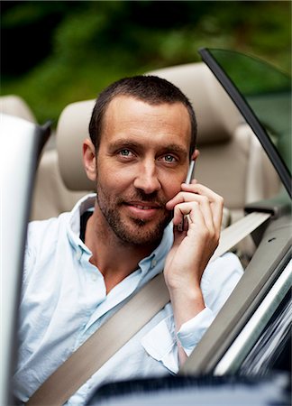 simsearch:700-00071660,k - Portrait of man in convertible car talking on phone Stock Photo - Premium Royalty-Free, Code: 6102-08800336
