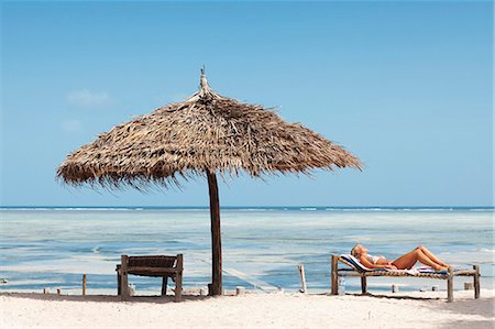 Young woman sunbathing on beach Stock Photo - Premium Royalty-Free, Code: 6102-08800453