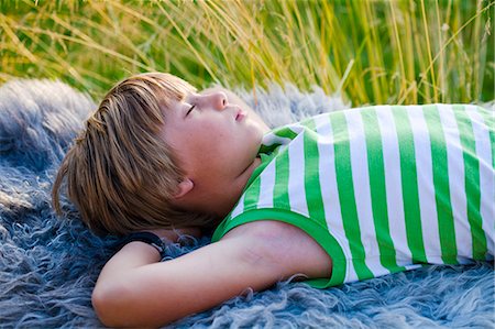 simsearch:6102-06336624,k - Boy sleeping on blanket outdoors Foto de stock - Sin royalties Premium, Código: 6102-08800420