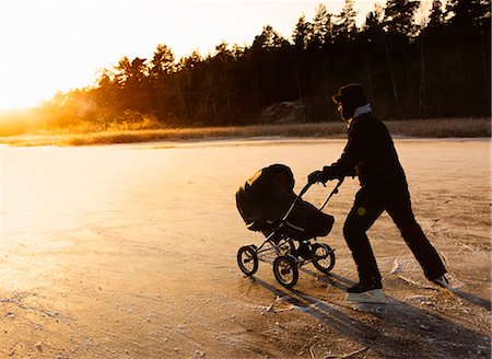 Father skating with a baby carriage, Sweden. Stock Photo - Premium Royalty-Free, Code: 6102-08800527