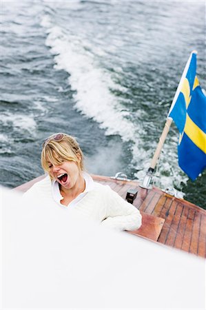 simsearch:6102-03867196,k - Blond woman in a motorboat, Sweden. Photographie de stock - Premium Libres de Droits, Code: 6102-08800532