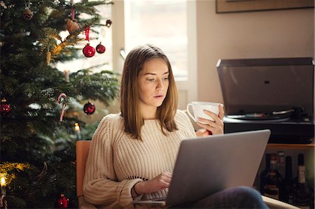 photos of christmas day living rooms - Woman using laptop in living room Stock Photo - Premium Royalty-Free, Code: 6102-08942245