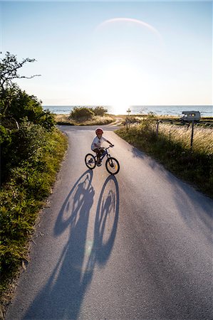 simsearch:6102-08559111,k - Boy cycling on country road Stock Photo - Premium Royalty-Free, Code: 6102-08942263