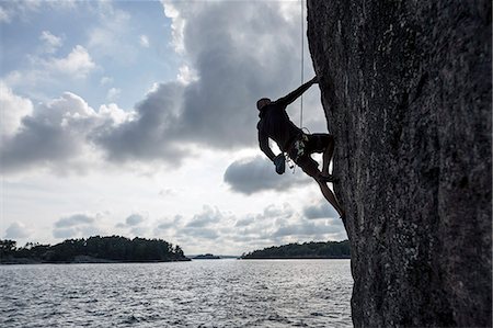 simsearch:6102-08384370,k - Man climbing cliff Foto de stock - Sin royalties Premium, Código: 6102-08942266