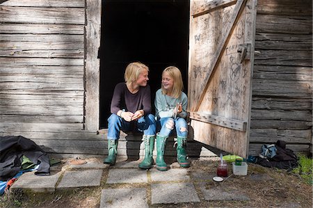 rain boots for girls - Girl and teenage boy sitting in front of barn Stock Photo - Premium Royalty-Free, Code: 6102-08942610