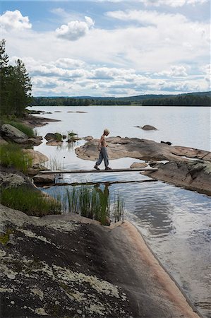 simsearch:6102-08996792,k - Boy walking on log bridge Foto de stock - Sin royalties Premium, Código: 6102-08951299