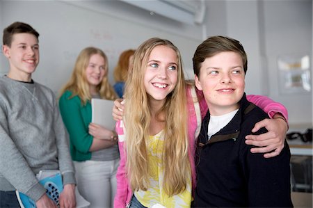 Teenagers embracing in classroom Foto de stock - Sin royalties Premium, Código: 6102-08951221
