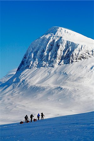 simsearch:6102-08063071,k - Tourists cross country skiing against mountain scenery Foto de stock - Sin royalties Premium, Código: 6102-08951326