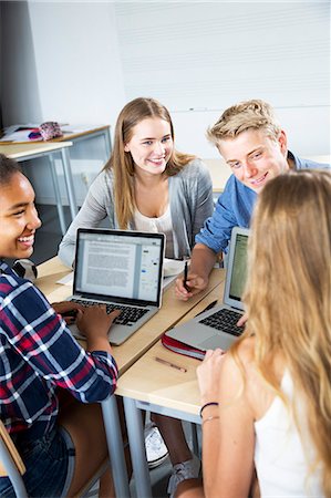 simsearch:6102-08951246,k - Teenagers with laptop in classroom Fotografie stock - Premium Royalty-Free, Codice: 6102-08951337