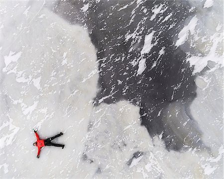 people air view - Man lying on frozen lake Stock Photo - Premium Royalty-Free, Code: 6102-08951557