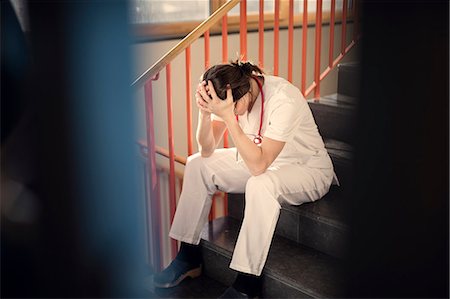 Female doctor sitting on stairs Stock Photo - Premium Royalty-Free, Code: 6102-08951918