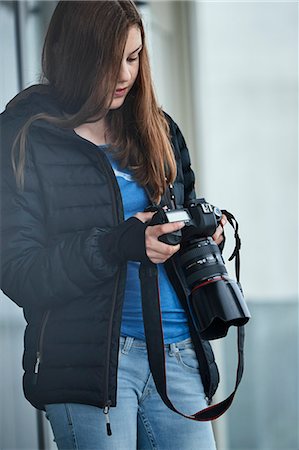 Teenage girl looking at digital camera Stock Photo - Premium Royalty-Free, Code: 6102-08951933