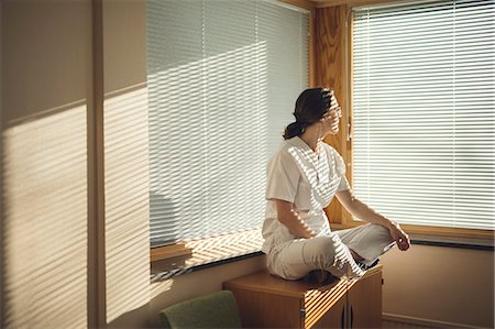 Female doctor sitting by window Stock Photo - Premium Royalty-Free, Code: 6102-08952050