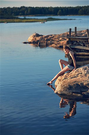 simsearch:6102-08952062,k - Teenage girl sitting on rock by lake Stock Photo - Premium Royalty-Free, Code: 6102-08952072
