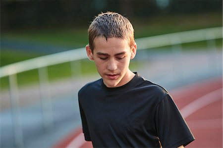 simsearch:6102-08271496,k - Teenage boy looking down on running track Foto de stock - Royalty Free Premium, Número: 6102-08952002