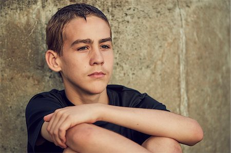 portrait boy arms crossed - Serious teenage boy against concrete wall Stock Photo - Premium Royalty-Free, Code: 6102-08952019