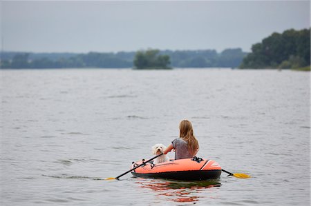 simsearch:6102-07769279,k - Young woman with dog swimming in inflatable raft Stock Photo - Premium Royalty-Free, Code: 6102-08994629