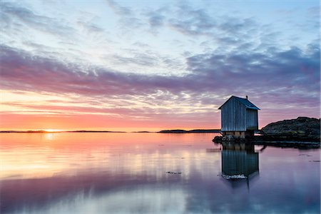 Wooden house at sunset Foto de stock - Royalty Free Premium, Número: 6102-08994756