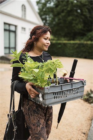 simsearch:6102-08270743,k - Woman carrying plants Photographie de stock - Premium Libres de Droits, Code: 6102-08995314