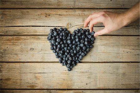 Hand making heart out of blueberries Stock Photo - Premium Royalty-Free, Code: 6102-08995456