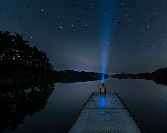 Person with headlight on jetty Stock Photo - Premium Royalty-Free, Image code: 6102-08995722