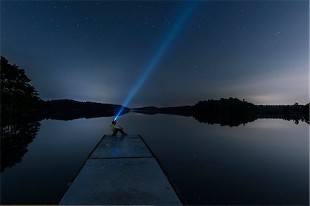 Person with headlight on jetty Stock Photo - Premium Royalty-Free, Code: 6102-08995724