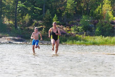 simsearch:6102-08995585,k - Mother and son running through water Photographie de stock - Premium Libres de Droits, Code: 6102-08995901