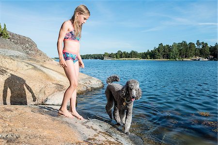 Girl at lake with dog Stock Photo - Premium Royalty-Free, Code: 6102-08995923