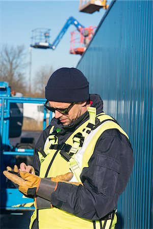 simsearch:6102-08996357,k - Worker on construction site using smartphone Photographie de stock - Premium Libres de Droits, Code: 6102-08996360