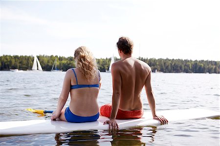 simsearch:6102-07790011,k - Couple sitting on paddleboard Foto de stock - Sin royalties Premium, Código: 6102-08996364