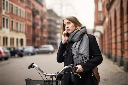 simsearch:6102-08942408,k - Young woman with bicycle on the phone Stockbilder - Premium RF Lizenzfrei, Bildnummer: 6102-08996376