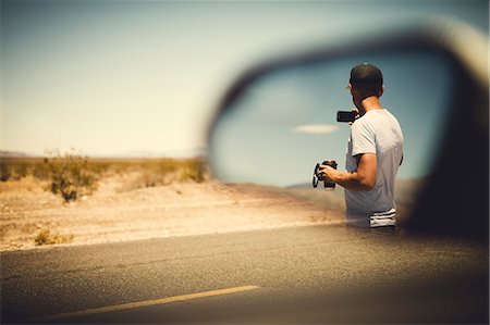 Man reflecting in side view mirror Stock Photo - Premium Royalty-Free, Code: 6102-08996441