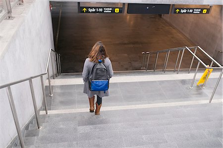 simsearch:6102-08481170,k - Woman walking down stairs Foto de stock - Royalty Free Premium, Número: 6102-08996744