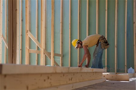 playboy men - Carpenter placing a stud in a wall frame Stock Photo - Premium Royalty-Free, Code: 6105-05395966