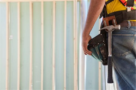 Mid section view of a carpenter wearing a tool belt Stock Photo - Premium Royalty-Free, Code: 6105-05395968