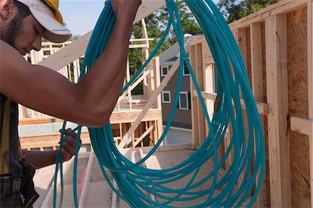 simsearch:6105-05396262,k - Hispanic carpenter unwinding an air hose at a house under construction Foto de stock - Royalty Free Premium, Número: 6105-05395978