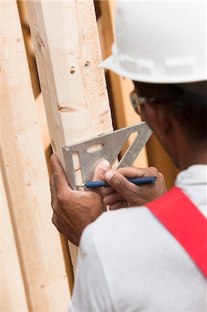 simsearch:6105-05396262,k - Hispanic carpenter measuring house frame with a rafter square Foto de stock - Royalty Free Premium, Número: 6105-05395989