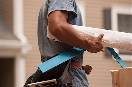 factory plans - Mid section view of a carpenter carrying a steel square and a blueprint Stock Photo - Premium Royalty-Free, Code: 6105-05395998