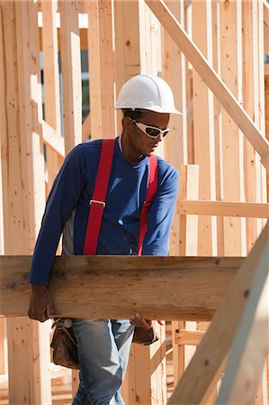 Carpenter carrying a wooden beam Stock Photo - Premium Royalty-Free, Code: 6105-05396060