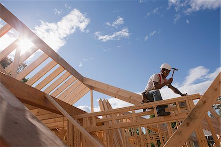 simsearch:6105-06043027,k - Low angle view of a carpenter hammering wall headers Stock Photo - Premium Royalty-Free, Code: 6105-05396074