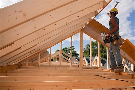 simsearch:6105-06043027,k - Carpenter hammering on roof rafters Stock Photo - Premium Royalty-Free, Code: 6105-05396076