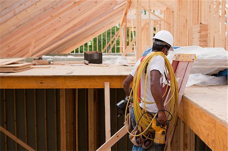 fio elétrico - Carpenter moving tools down ladder at end of day to go home Foto de stock - Royalty Free Premium, Número: 6105-05396079