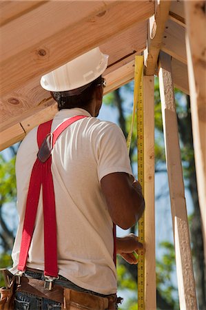 simsearch:6105-05396084,k - Carpenter measuring roof rafters Stock Photo - Premium Royalty-Free, Code: 6105-05396083